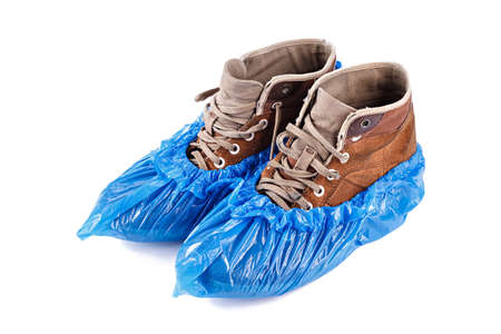 Blue protective shoe covers on men's shoes isolated on white background