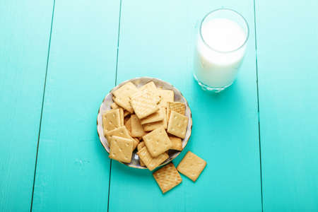 healthy breakfast glass of milk and crackers on a wooden blue surface, close up, top viewの写真素材