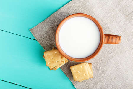 healthy breakfast cup of milk and crackers on a wooden blue surface, on linen napkin, close up, top vew の写真素材