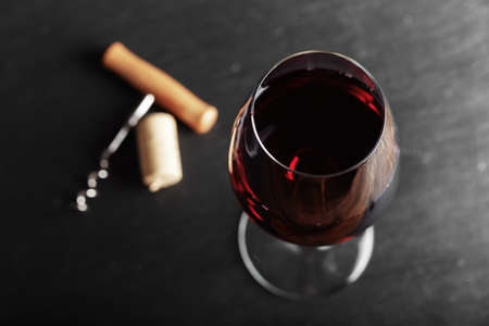 wine glass of red wine with a corkscrew. On a black wooden background. の写真素材
