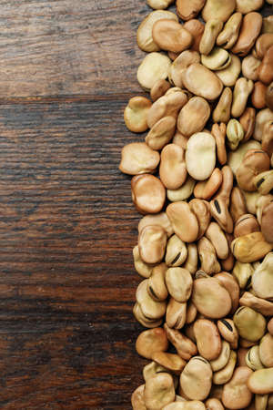 raw dry beans are scattered on a wooden background