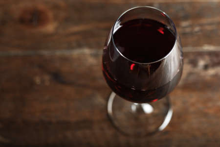 glass with red wine view from above, on a wooden background, space for textの写真素材