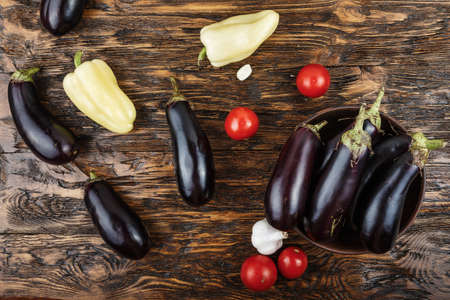 Vegetables on vintage wood background - summer harvest, soup ingredients. Rural still life from above. Tomato, eggplant, garlic, pepperの写真素材