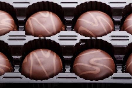 chocolate candy in a box on a black background, romantic gift