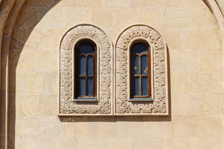 old windows of an arch on a wall of a building of sand color