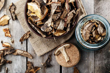 dried mushrooms boletus sliced, on a plate, on an old wooden backgroundの写真素材
