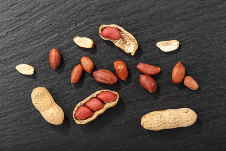 peanuts on black background, top view, space for text