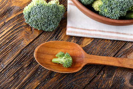 broccoli in a clay plate on a wooden table. with space for text