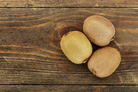 kiwi on a wooden background, the texture of the fruit is clearly visible. place for textの写真素材