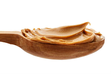 spoon with natural organic peanut butter, on white background, isolated