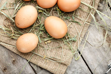 fresh organic farm eggs lie on burlap, on a wooden background