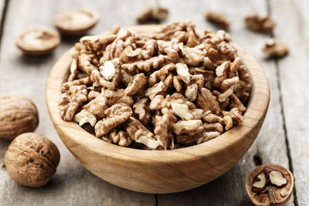 walnuts on a wooden background, in a plate. a useful nutritious protein product. place for text