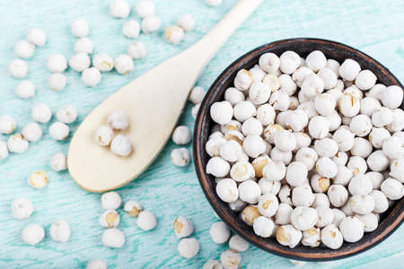 raw chickpeas in a plate on a wooden background, organic food, vegetarian cuisineの写真素材