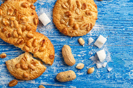 appetizing homemade cookies with peanuts on a blue shabby wooden background, biscuits broken. top view, space for textの写真素材