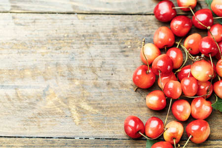 Close up of pile of ripe cherries with stalks and leaves. Large collection of fresh red cherries....