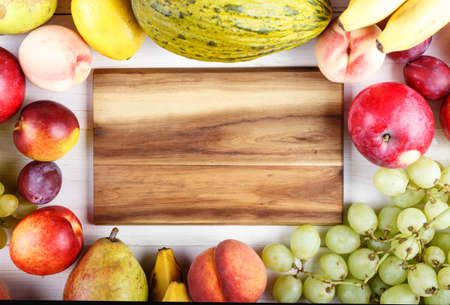 ripe fruit, in the center - a board for the text as background - bananas, oranges, plums, apples and exotic fruitsの写真素材