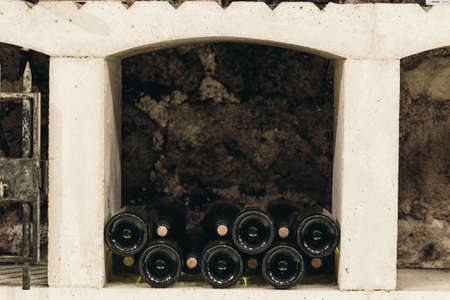 Bottles of wine in a wine cabinet in an old wine cellar, space for text
