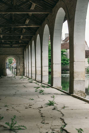 arch along the building,  a long cracked cement pathの写真素材
