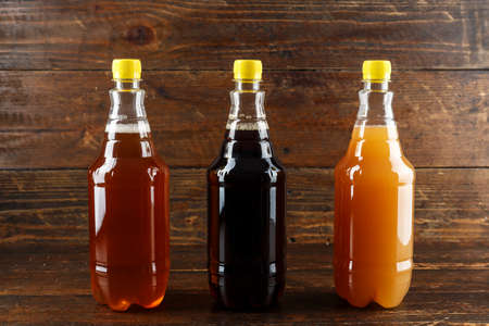 different varieties of craft beer in plastic bottles on a wooden background