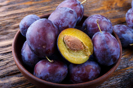 Garden plums in bowl. Organic food. Top view with copy space for your textの写真素材