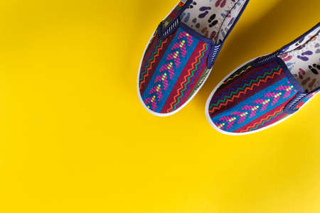 bright multi-colored women's shoes on a yellow background. comfortable trend shoes for summer
の写真素材