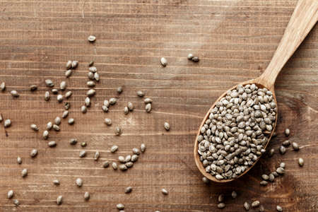 hemp seeds in a rustic wooden spoon in a wooden, space for textの写真素材