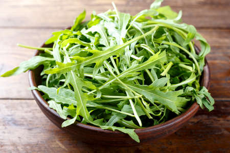 fresh rucola salad chopped on a wooden background, space for textの写真素材