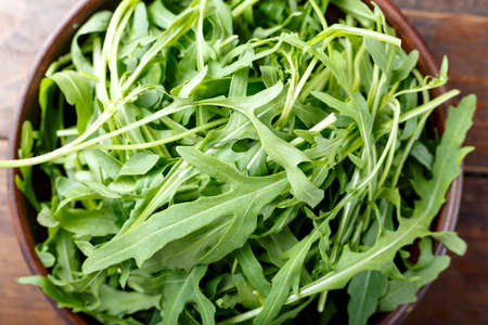 fresh rucola salad chopped on a wooden background, space for textの写真素材