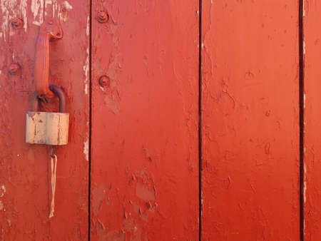 wooden red shabby background. clearly visible texture of the jerk and cracked paint. there is a lock on the doorの写真素材