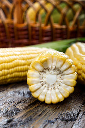 sweet young raw corn on a wooden background. maize is peeledの写真素材