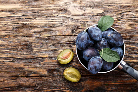 juicy plum on a wooden table, top view. place for textの写真素材