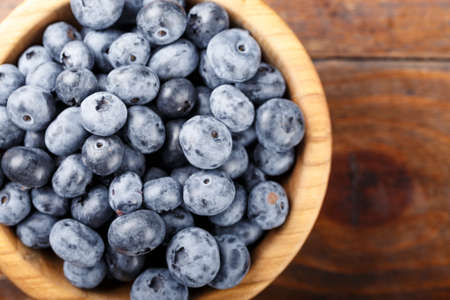 blueberry in a wooden plate on a wooden background, space for textの写真素材