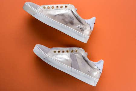 women's new sneakers on an orange background, space for text, top viewの写真素材