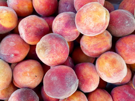 a lot of ripe peaches as a background. Peaches are sold on the market. close-up. place for text