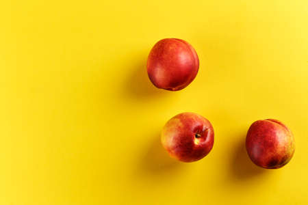 Ripe nectarine on a yellow background, space for text.の写真素材