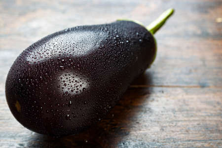 ripe eggplant on a wooden table, close-up. place for text