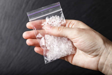 a bag of drugs in the form of white crystals in hand