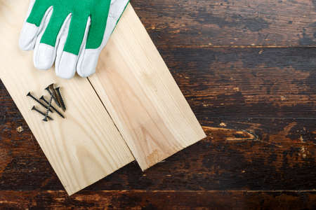 Work gloves and carpenter's tools on a wooden table. place for text