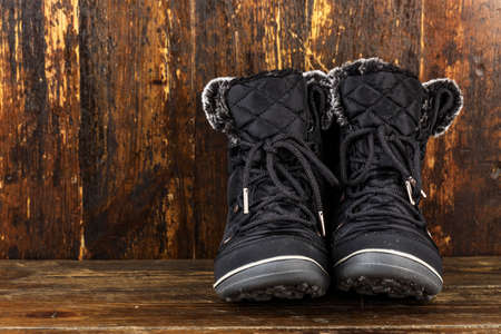women's winter boots made of textiles. shoes for travel and long walks. seasonal boots on a wooden...