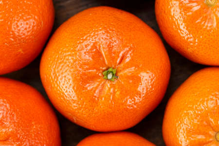 tangerines in peel close-up lie as background. peel shiny. well visible texture of fruit
