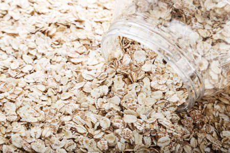raw oatmeal scattered as a background. cooking oatmeal breakfast