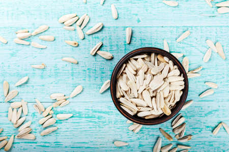white sunflower seeds are scattered on the table and poured into a plate. view from aboveの写真素材