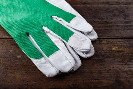 clean working gloves white-green on a brown wooden table. place for textの写真素材