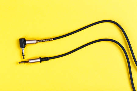 cable to a mobile phone on a yellow background. place for text