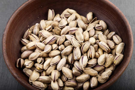 pistachios in a plate on a black background. space for text