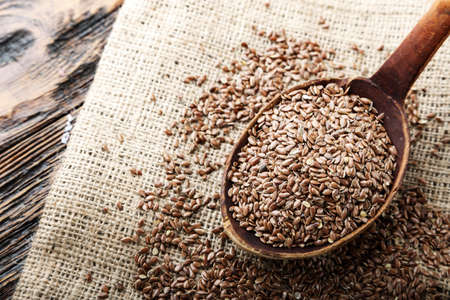 wooden spoon with flax seed placed on a wooden tableの写真素材