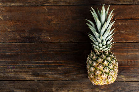 fresh pineapple on wooden background. exotic fruit for dessertの写真素材