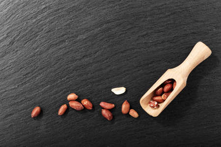 raw peeled peanuts scattered on a black background. space for textの写真素材