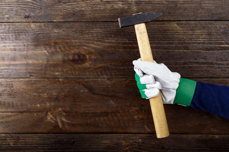 hammer in the hand of the master. work tool on wooden background. space for textの写真素材