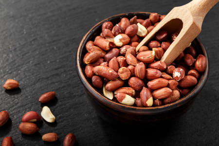 peeled peanuts on a black background. space for text